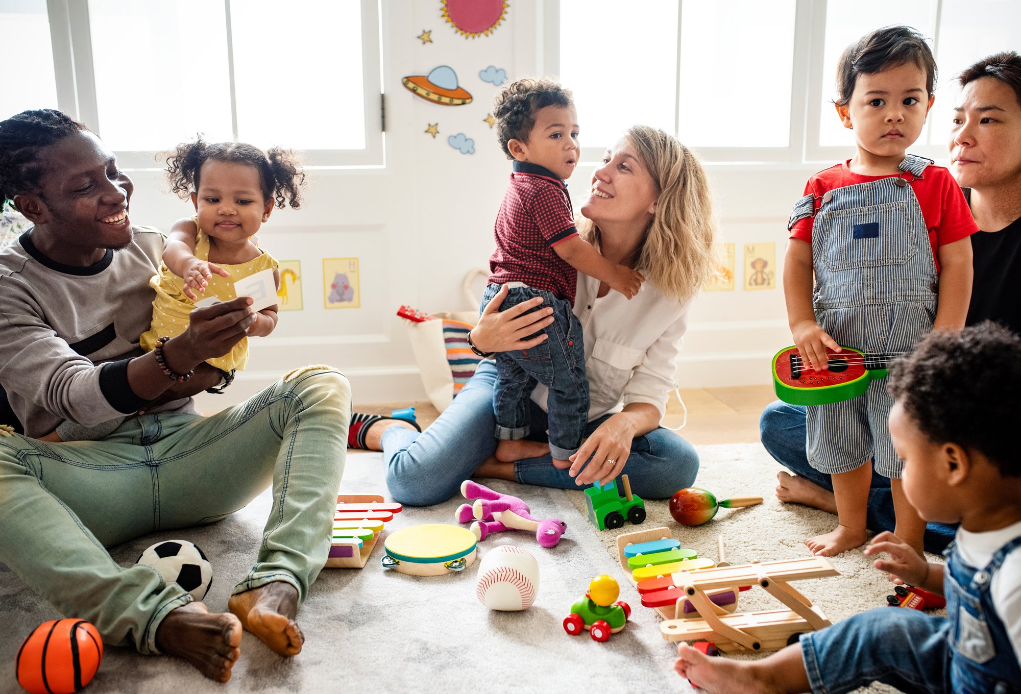 preschool children playing on floor with parent